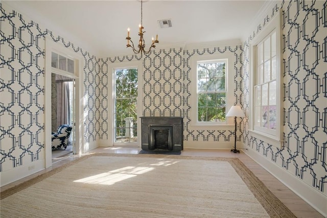 unfurnished living room featuring crown molding, visible vents, a fireplace, and wallpapered walls