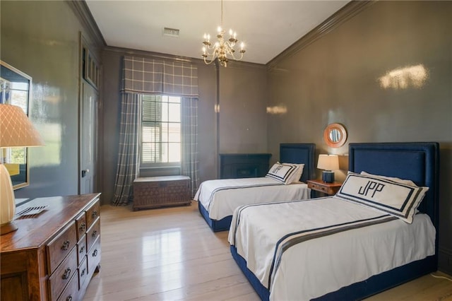 bedroom featuring crown molding, an inviting chandelier, and light hardwood / wood-style flooring