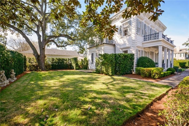 view of front of house with a balcony and a front yard