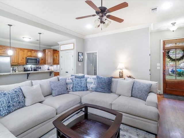 living room featuring dark hardwood / wood-style flooring, ceiling fan, and ornamental molding