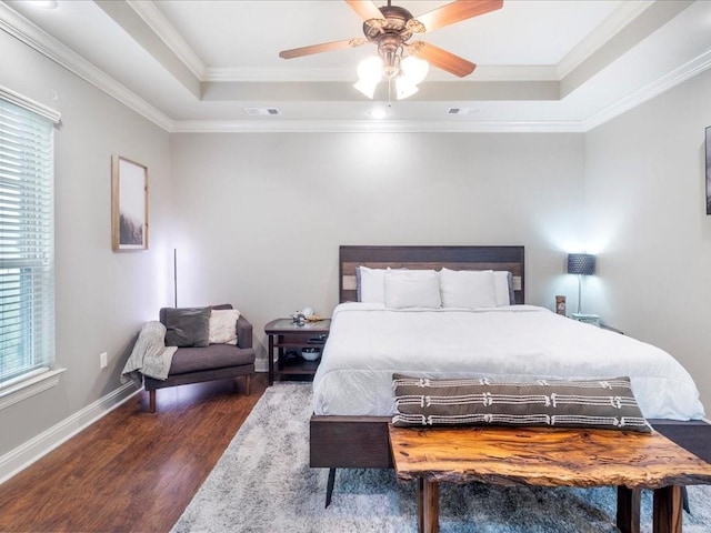 bedroom featuring dark hardwood / wood-style floors, a raised ceiling, ceiling fan, and ornamental molding