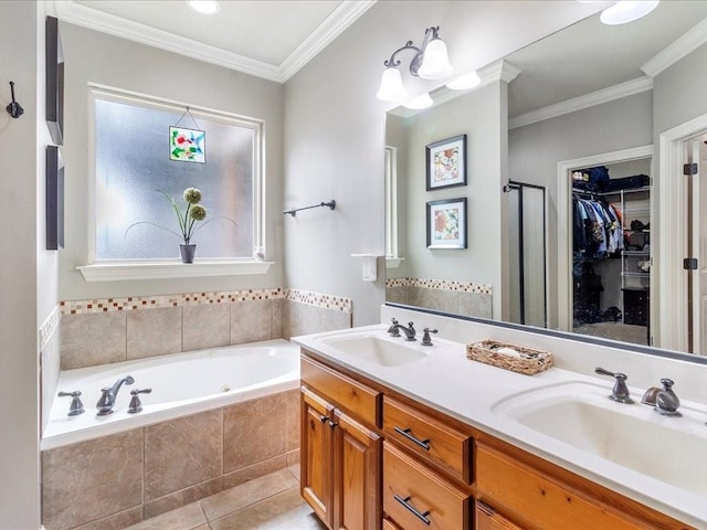 bathroom featuring tile patterned flooring, vanity, ornamental molding, and tiled bath