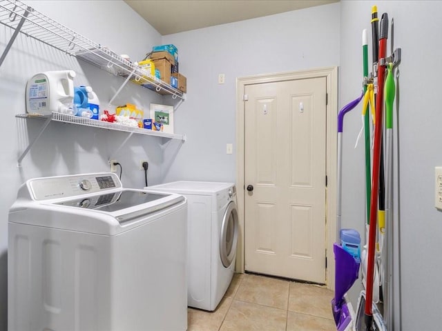 washroom featuring washing machine and dryer and light tile patterned floors