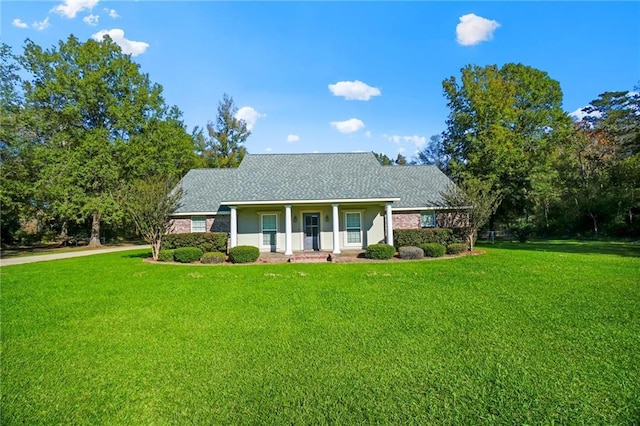 ranch-style house featuring a front lawn, roof with shingles, and a porch