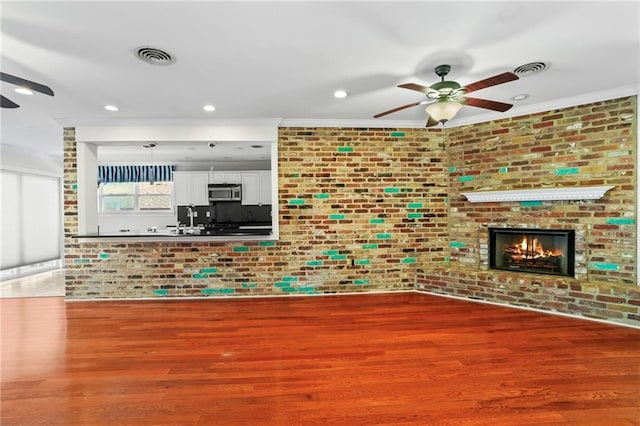 136 Rebel Ave, River Ridge, LA 70123 - unfurnished living room with ceiling fan, brick wall, ornamental molding, wood finished floors, and recessed lighting
