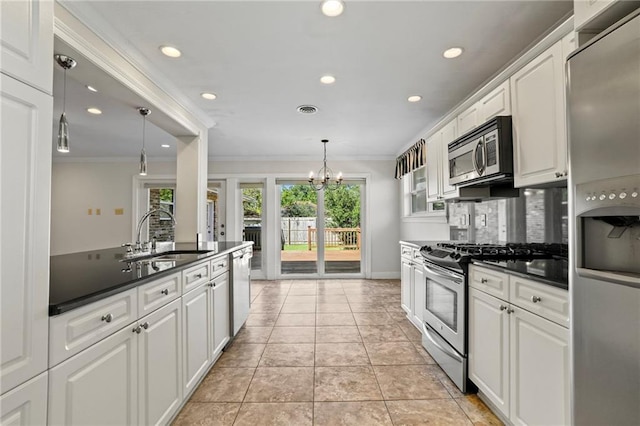 kitchen featuring white cabinets, decorative light fixtures, and appliances with stainless steel finishes