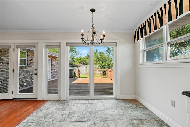 136 Rebel Ave, River Ridge, LA 70123 - doorway to outside featuring a chandelier, baseboards, and ornamental molding