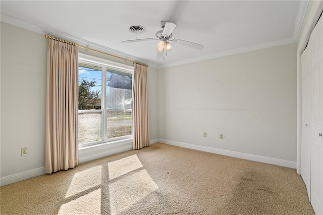 spare room with light colored carpet, ceiling fan, and crown molding