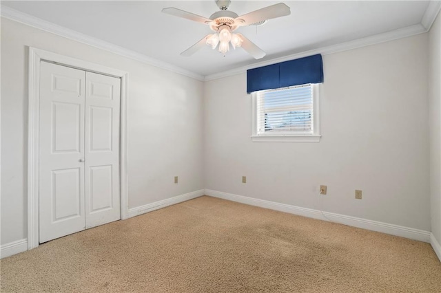 unfurnished bedroom featuring carpet flooring, a closet, ceiling fan, and ornamental molding