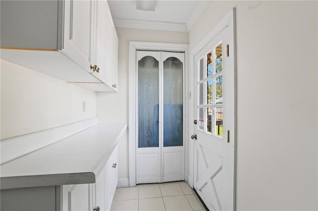 doorway with light tile patterned flooring and ornamental molding