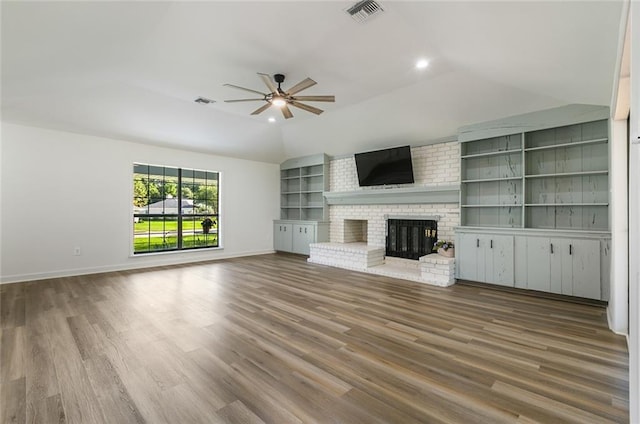 unfurnished living room featuring hardwood / wood-style flooring, ceiling fan, and a fireplace