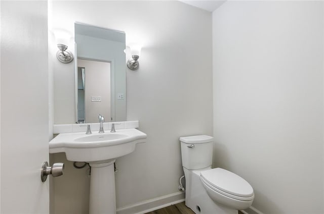 bathroom featuring wood-type flooring and toilet