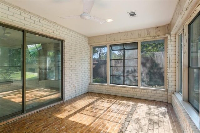 unfurnished sunroom with ceiling fan