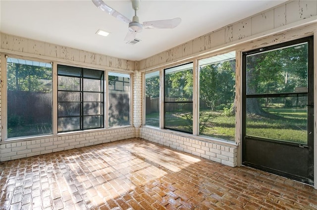 unfurnished sunroom featuring ceiling fan