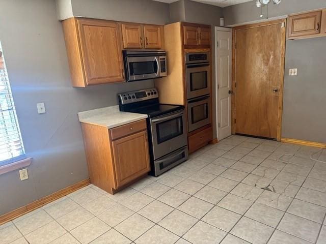 kitchen with ceiling fan, light tile patterned flooring, and appliances with stainless steel finishes