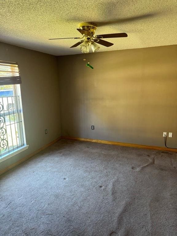 unfurnished room with ceiling fan, carpet, and a textured ceiling