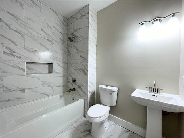 bathroom featuring tiled shower / bath combo and toilet