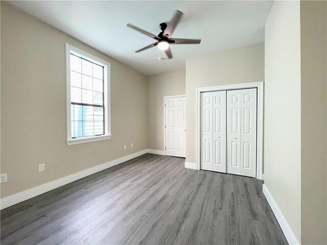 343335 Magnolia St, New Orleans, LA 70115 - unfurnished bedroom with wood finished floors, a closet, and a ceiling fan
