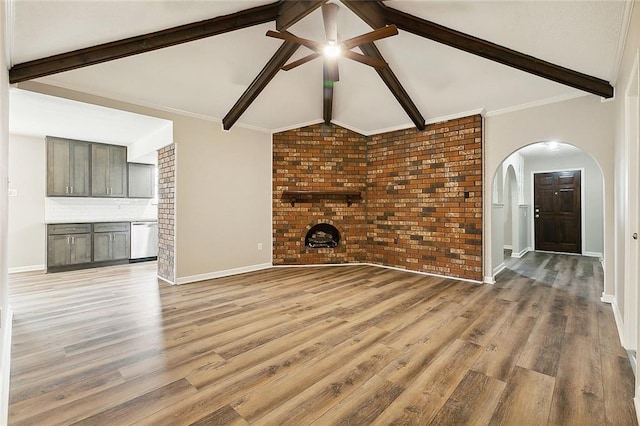 unfurnished living room featuring lofted ceiling with beams, brick wall, and light wood-type flooring