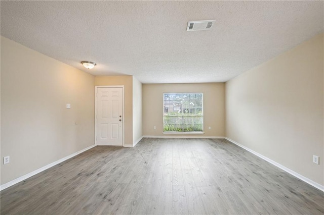 spare room with wood-type flooring and a textured ceiling