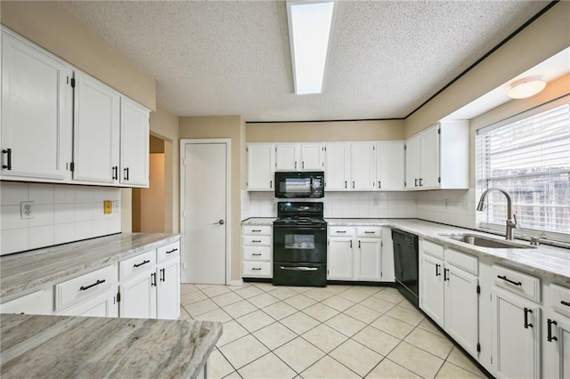 kitchen with white cabinets, sink, light stone countertops, and black appliances