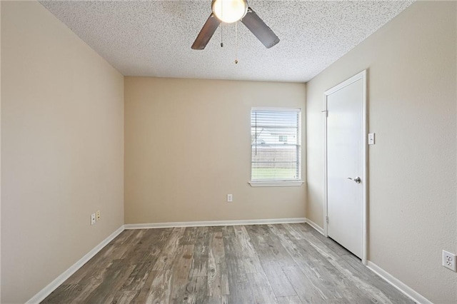 empty room with hardwood / wood-style floors, a textured ceiling, and ceiling fan