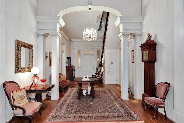 2513 Red Lick Rd, Lorman, MS 39096 - entryway featuring ornate columns, wood-type flooring, a towering ceiling, a decorative wall, and a chandelier