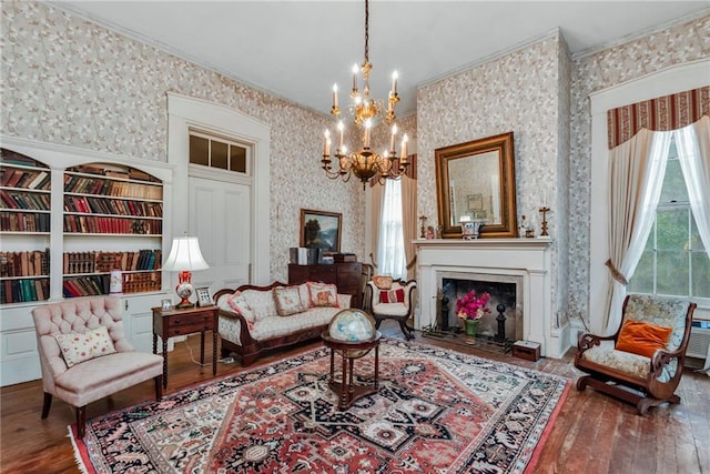 2513 Red Lick Rd, Lorman, MS 39096 - living room featuring a chandelier, hardwood / wood-style floors, crown molding, wallpapered walls, and a fireplace