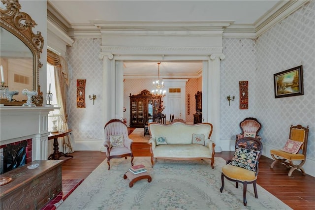 2513 Red Lick Rd, Lorman, MS 39096 - living area featuring hardwood / wood-style flooring, a chandelier, ornamental molding, wallpapered walls, and a fireplace with raised hearth