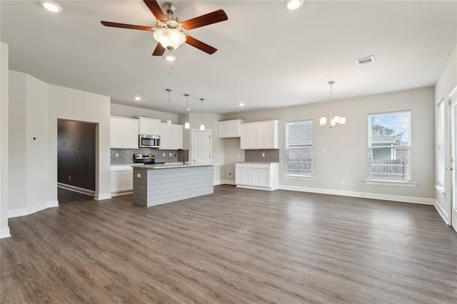 kitchen featuring white cabinets, pendant lighting, stainless steel appliances, and a kitchen island with sink