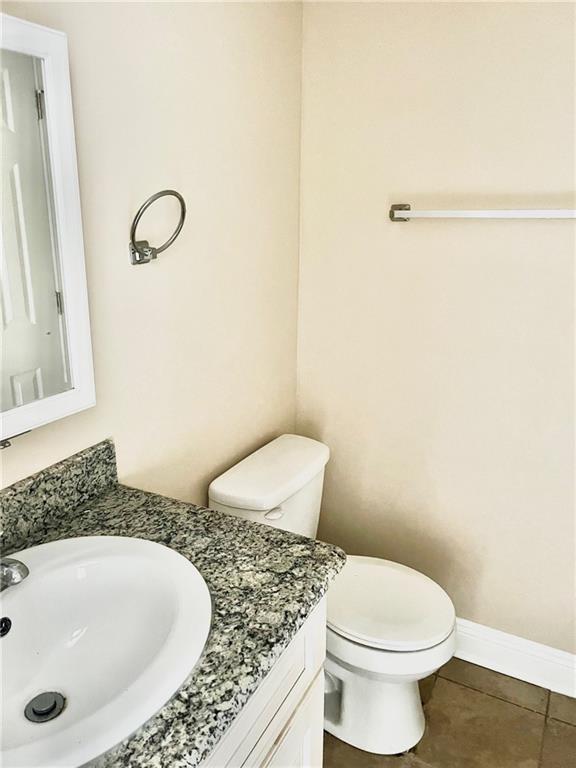 bathroom featuring tile patterned flooring, vanity, and toilet