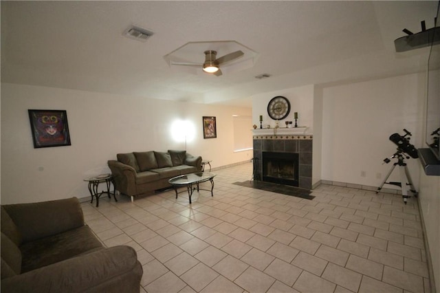 living room featuring light tile patterned floors, ceiling fan, and a tiled fireplace