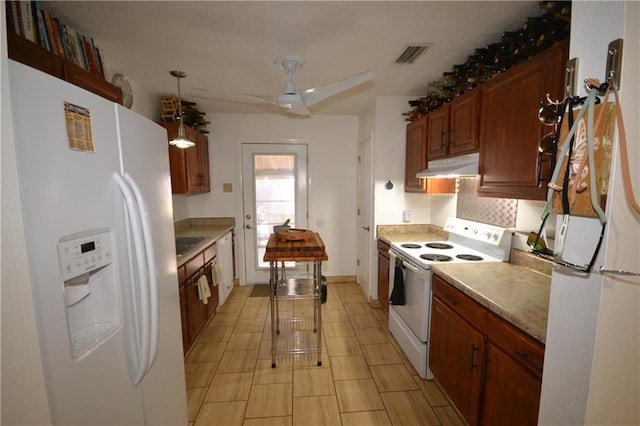 kitchen with a breakfast bar, white appliances, backsplash, ceiling fan, and decorative light fixtures