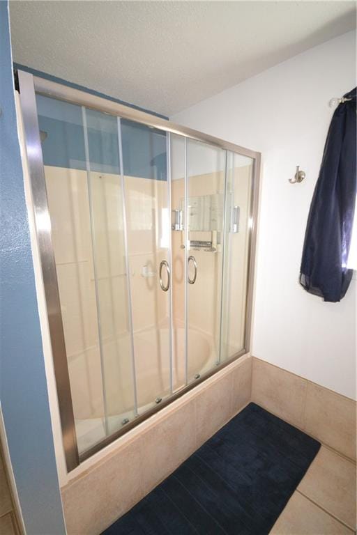 bathroom featuring tile patterned floors and shower / bath combination with glass door