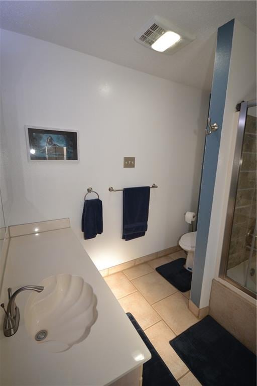 full bathroom with tile patterned flooring, combined bath / shower with glass door, toilet, and vanity