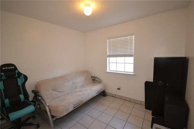 living area with light tile patterned floors and a textured ceiling