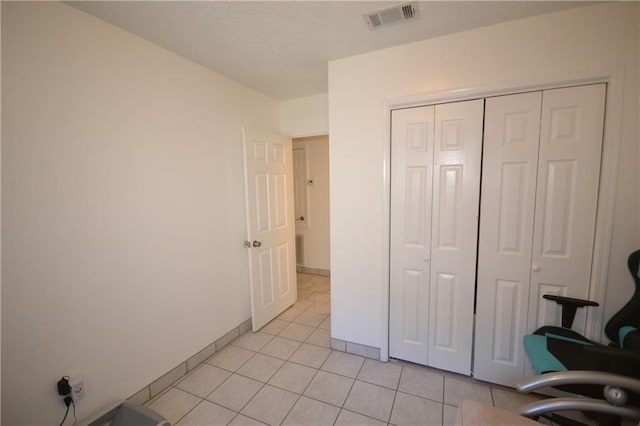 interior space featuring a closet and light tile patterned floors