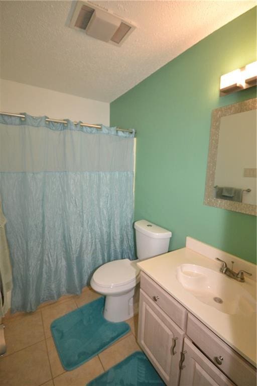 bathroom featuring walk in shower, tile patterned floors, a textured ceiling, toilet, and vanity