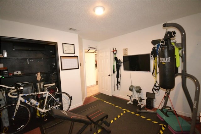 exercise room featuring a textured ceiling