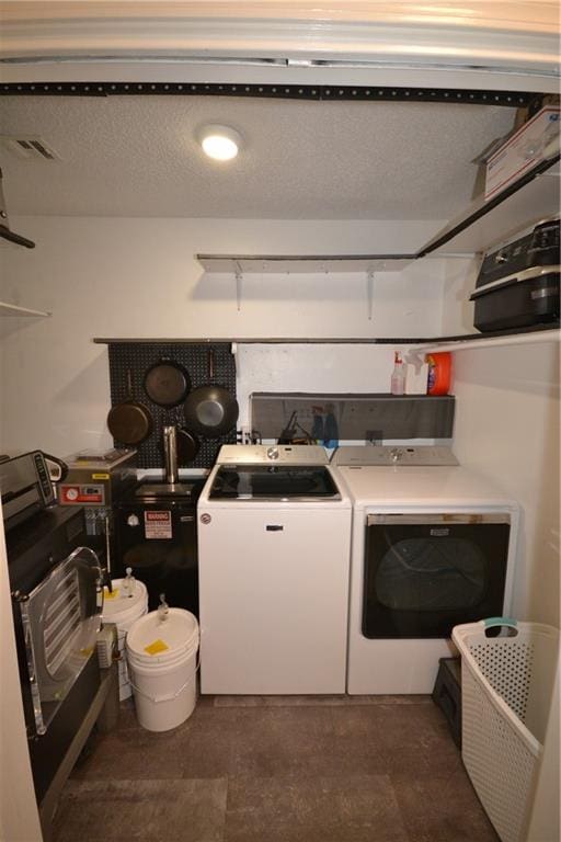 washroom featuring a textured ceiling and washer and clothes dryer