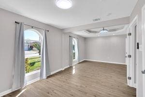 unfurnished room with ceiling fan and wood-type flooring