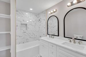 bathroom with tiled shower / bath combo and vanity