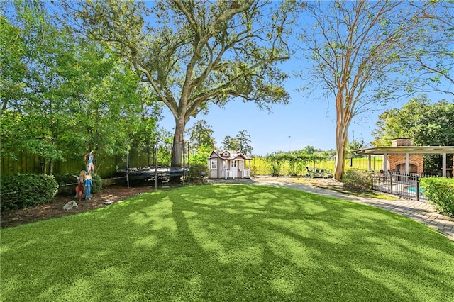 view of yard featuring a storage shed and a trampoline