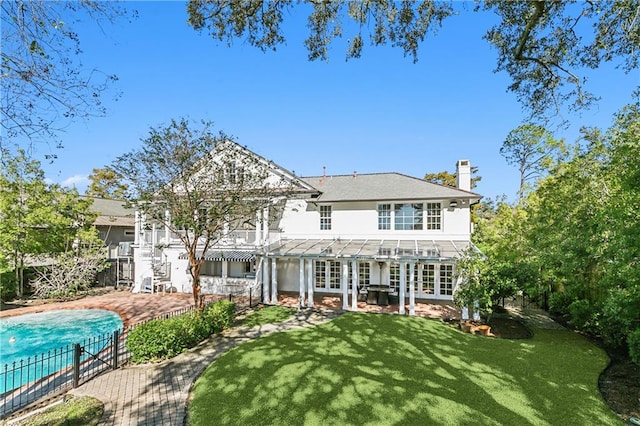 rear view of property with a yard, a patio, and french doors