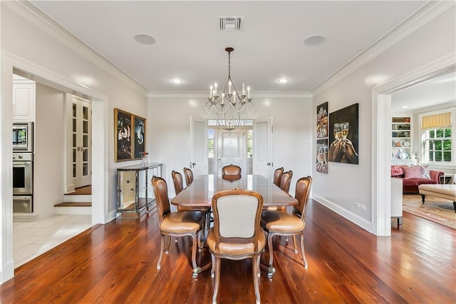 dining room featuring hardwood / wood-style flooring, crown molding, and a notable chandelier