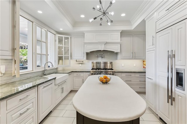 kitchen with stainless steel range, white cabinetry, and sink