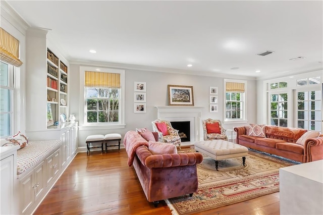 living room featuring ornamental molding, a healthy amount of sunlight, and light hardwood / wood-style floors