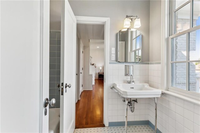 bathroom with sink, wood-type flooring, and tile walls