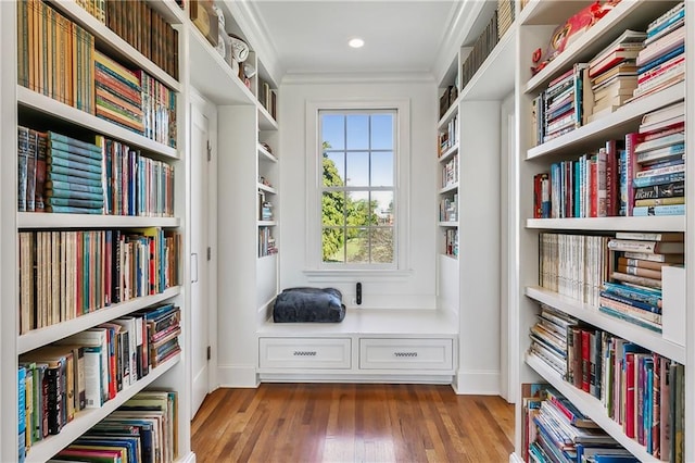 living area featuring wood-type flooring and crown molding