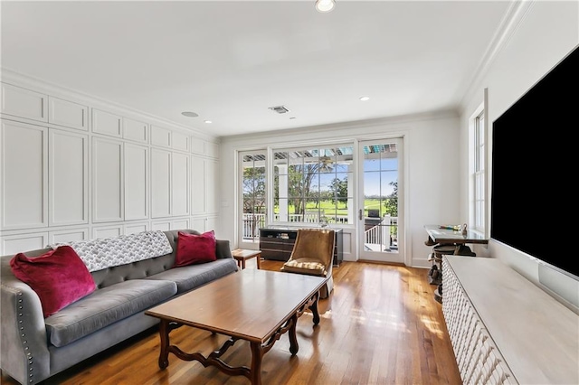 living room featuring light hardwood / wood-style flooring and ornamental molding